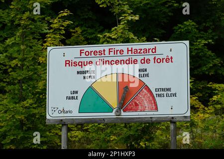 Algonquin Park, Ontario, Canada - 26 agosto 2022: Un cartello di pericolo di incendio nella foresta dell'Ontario con un indicatore illustrato indica un elevato livello di rischio di incendio. Foto Stock