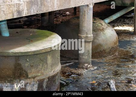 Contenitori in calcestruzzo per acque reflue e acque reflue sotto l'edificio su pilastri Foto Stock