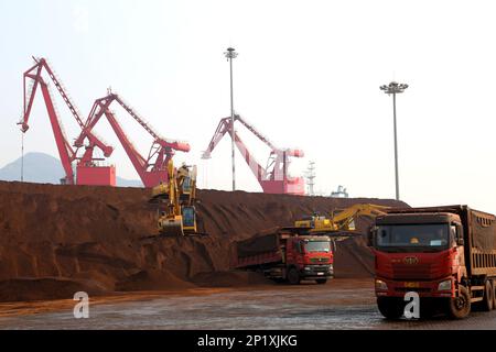 LIANYUNGANG, CINA - 4 MARZO 2023 - il minerale di ferro importato viene scaricato e accatastato nel porto di Lianyungang, nella provincia di Jiangsu della Cina orientale, il 4 marzo 202 Foto Stock