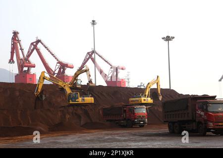 LIANYUNGANG, CINA - 4 MARZO 2023 - il minerale di ferro importato viene scaricato e accatastato nel porto di Lianyungang, nella provincia di Jiangsu della Cina orientale, il 4 marzo 202 Foto Stock