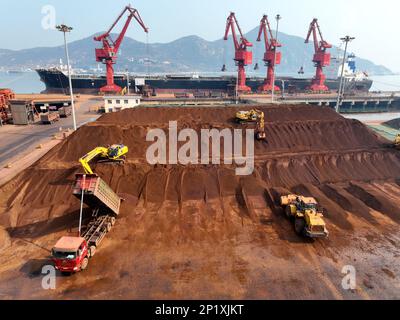 LIANYUNGANG, CINA - 4 MARZO 2023 - il minerale di ferro importato viene scaricato e accatastato nel porto di Lianyungang, nella provincia di Jiangsu della Cina orientale, il 4 marzo 202 Foto Stock