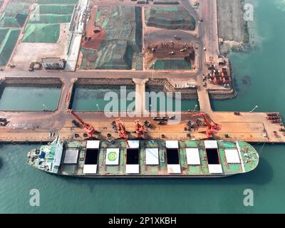 LIANYUNGANG, CINA - 4 MARZO 2023 - il minerale di ferro importato viene scaricato e accatastato nel porto di Lianyungang, nella provincia di Jiangsu della Cina orientale, il 4 marzo 202 Foto Stock