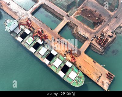 LIANYUNGANG, CINA - 4 MARZO 2023 - il minerale di ferro importato viene scaricato e accatastato nel porto di Lianyungang, nella provincia di Jiangsu della Cina orientale, il 4 marzo 202 Foto Stock