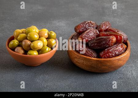Frutta da datare con olive verdi su fondo scuro Foto Stock