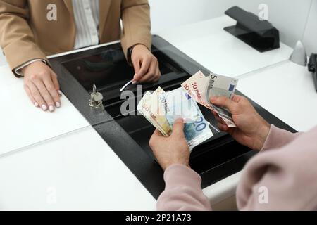 Uomo che si scambiano denaro in banca, vista in primo piano Foto Stock