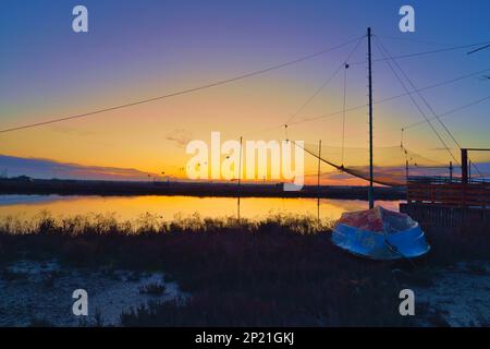 Tramonto sulla palude, con una vecchia barca sulla destra (Porto Corsini) Foto Stock