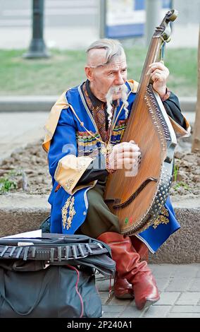 Un Kobzar che canta al suo proprio accompagnamento su uno strumento bandura in via Khreshchatyk a Kyiv, Ucraina. Foto Stock