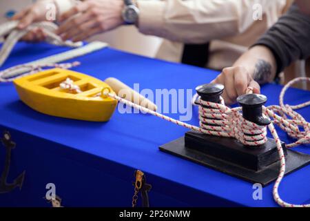 I bambini ad imparare a moro sulla nave giocattolo modello presso la scuola di vela. Piccola barca legata a un bollard con linea di ormeggio. Foto Stock