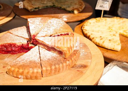 Fette di torte varie al mercato alimentare. Pezzi di taglio di una torta di frutta Foto Stock