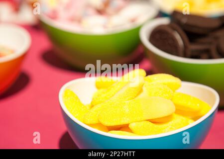Giallo gelatine, cookie e altri dolciumi in bright bocce. Divertimento coloratissimo close-up di vari tipi di dolci. Spuntini gustosi campioni al negozio di dolciumi Foto Stock