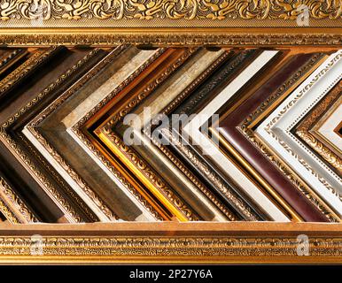 Stile antico in legno dorato campioni del telaio dello sfondo. Decorativi ornati cornici schermo ad un negozio d'arte Foto Stock