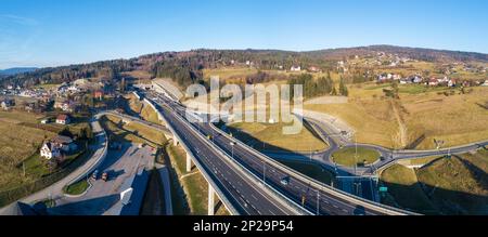 Polonia. Autostrada Zakopianka con tunnel appena aperto nel novembre 2022. Nodo di spaghetti multilivello con circoli stradali, viadotti, scivoli e tr Foto Stock