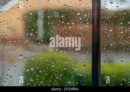 Fuoco poco profondo di gocce di pioggia fresca vista su una nuova installazione, finestra a doppio vetro. Guardando fuori ad un cut de sac privato. Foto Stock