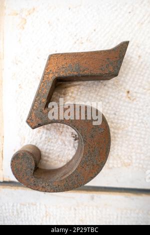 Grande simbolo dei cinque d'oro su una parete bianca Foto Stock