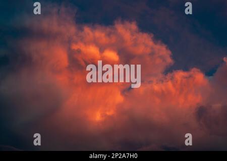 Il tramonto cremisi illumina le nuvole di pioggia in un colore sanguinoso. Cielo serale per l'intera cornice, maltempo Foto Stock