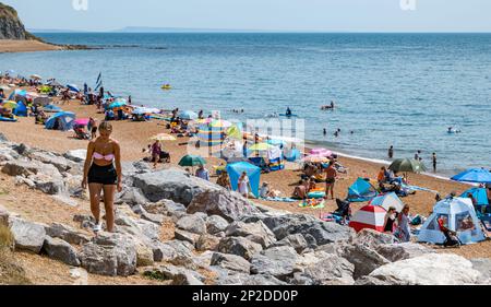 Gente sulla spiaggia di Seatown in estate sulla costa di Jurassic, Dorset, Inghilterra, Regno Unito Foto Stock
