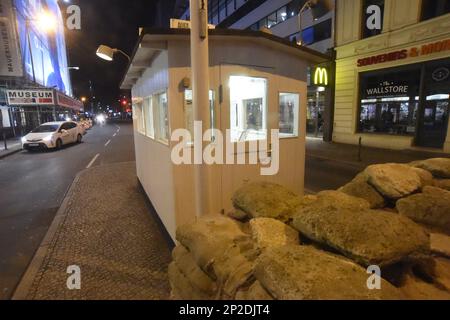 Berlino, Germania. 03rd Mar, 2023. La piccola casa di Checkpoint Charlie si illumina di notte. Il Checkpoint Charlie era uno dei valichi di frontiera di Berlino attraverso il muro di Berlino. Ha collegato il settore sovietico con il settore americano. Credit: Felix Hörhager/dpa/Alamy Live News Foto Stock