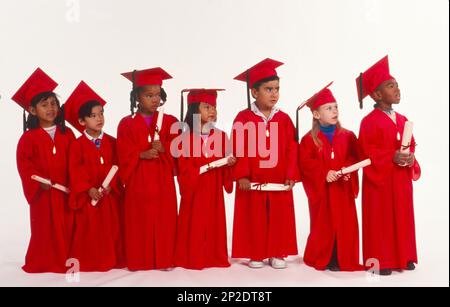 Linea di bambini vestiti con berretto rosso e camici in possesso di diplomi, di tutte le diverse etnie, che si sfuggono al fianco Foto Stock