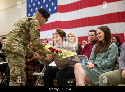 Michael Ratliff della Guardia Nazionale dell'Indiana presenta i fiori a Deedra Thombleson, moglie del Gen. Timothy Thombleson, durante una cerimonia di cambio di comando all'Armeria della Divisione Ciclone di Indianapolis, 22 gennaio 2023. Le rose rosse simboleggiano il sostegno che ha dimostrato alla Divisione Fanteria 38th. (Foto della Guardia Nazionale Indiana di Sgt. Kelsea Cook) Foto Stock