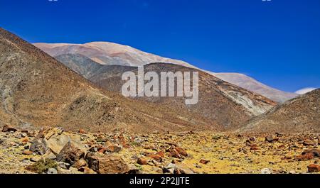 Avventura costiera sabbiosa pietra sentiero escursionistico in bella vita secca irreale ostile paesaggio desertico verso pareti di montagna apparentemente inpercorribili, blu sk Foto Stock