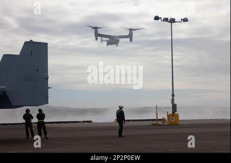 STATI UNITI Marines con Marine Medium Tiltrotor Squadron (VMM) 163, Marine Aircraft Group 16, 3rd Marine Aircraft Wing, guarda come un MV-22B Osprey si prepara ad atterrare al National City Pier a San Diego, 24 febbraio 2023. Lo squadrone ha messo in scena gli Ospreys per il trasporto marittimo per fornire agli elementi di combattimento e supporto dell'aviazione organizzata di compito. (STATI UNITI Corpo marino foto di Lance CPL. Courtney A. Robertson) Foto Stock