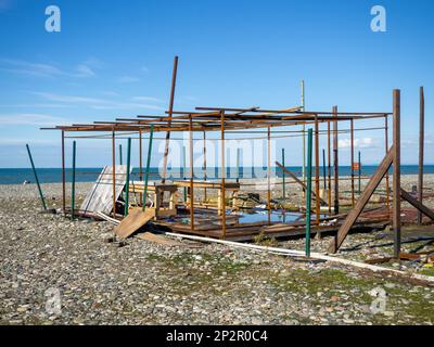 Stalla in rovina sulla spiaggia. Bassa stagione. Business abbandonato. Ricostruzione. Demolizione di stalle. Fallimento Foto Stock