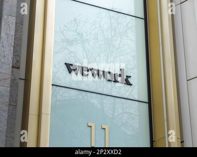 Logo WeWork sull'esterno di un edificio. Fornitore di spazi di co-working Office e spazi condivisi nella città di Berlino. Società americana di start up. Foto Stock
