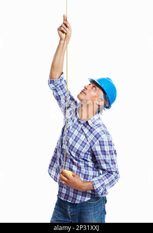 Lavoratore di costruzione. Architetto maturo in elmetto con metro a nastro su sfondo bianco. Foto Stock