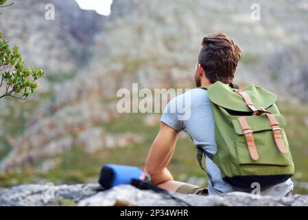 Godersi l'aria aperta. un bel giovane uomo che si gode la vista durante le escursioni. Foto Stock