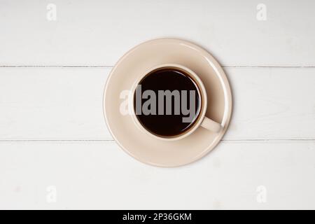 Topview della tazza di caffè nero su bianco sullo sfondo di legno con spazio di copia Foto Stock