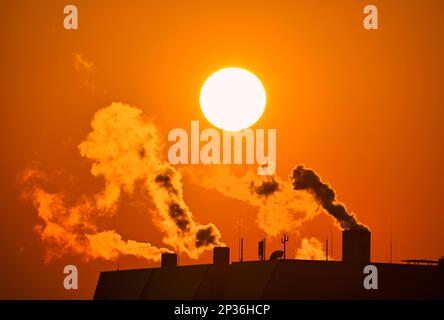 Fumo che esce da camini, impianti industriali, combustione, tramonto, sole serale, Stoccarda, Baden-Wuerttemberg, Germania Foto Stock