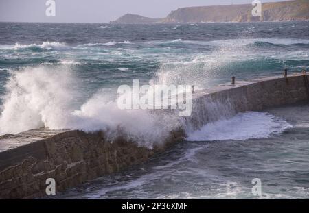 Onde che si infrangono sulla parete del porto, vista verso Capo Cornovaglia, Sennen Bay, Sennen, Cornovaglia, Inghilterra, Regno Unito Foto Stock