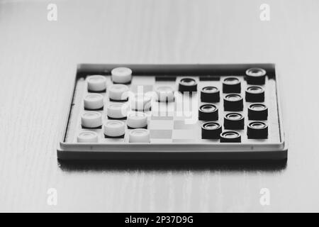 Scacchiera piccoli vecchi giochi sul tavolo, giochi da tavolo, foto ravvicinata in bianco e nero Foto Stock