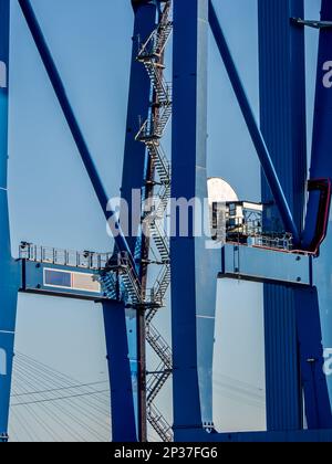 Vista laterale di una parte di una gru blu, compresa una lunga e suggestiva scala, contro il cielo blu, che mostra importanza ed efficienza. Foto Stock