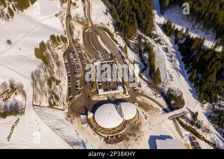 Fotografia di droni di stazioni sciistiche, parcheggi, montagne e boschi durante la giornata di sole inverno Foto Stock