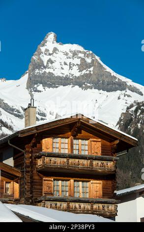 Tipico chalet svizzero di fronte alla vetta innevata del Petit Muveran, Ovronnaz, Vallese, Svizzera Foto Stock