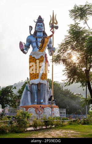 Statua del Signore Shiva in piedi, Dio Hidu a Har ki Pauri in Uttarakhand, India. Signore Shiva con tridente in mano e cobra serpente intorno al collo. Foto Stock