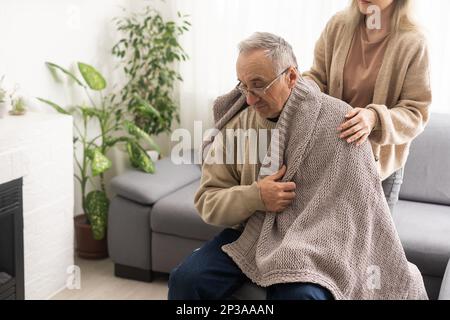 Testa ha sparato vecchio pensionato maschio coinvolto nella procedura di riabilitazione con giovane fisioterapista premuroso. uomo in pensione con sensazione di disabilità motoria Foto Stock