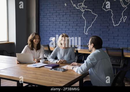 Allegro positivo diversi colleghi di affari donne che parlano con il capo maschio Foto Stock