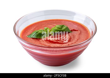 Tazza in vetro con salsa di purè di pomodoro con foglie di basilico isolato su bianco con percorso di taglio Foto Stock