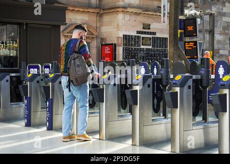 Passeggeri che utilizzano la barriera elettronica per l'accesso ai binari della stazione centrale di Glasgow, Scozia, Regno Unito Foto Stock