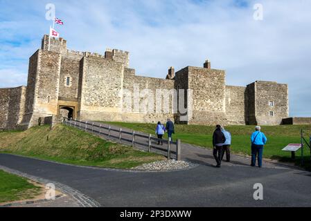 I visitatori che camminano lungo il sentiero che conduce alla porta del Palazzo, l'ingresso principale alle alte mura fortificate circostanti del Castello di dover a dover, Kent, Foto Stock