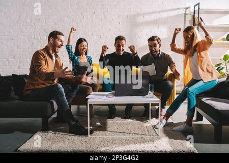 Gli uomini d'affari in ufficio sono felici per la tendenza aziendale e il successo della startup Foto Stock