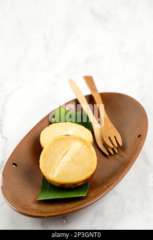 KUE Kuala Lumpur Indonesian Mud Cake, spuntino tradizionale a base di patate, farina, uova e latte di cocco con una fetta di formaggio Foto Stock