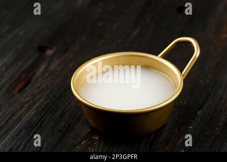 Vino di riso coreano Makgeolli nella Coppa d'oro Foto Stock