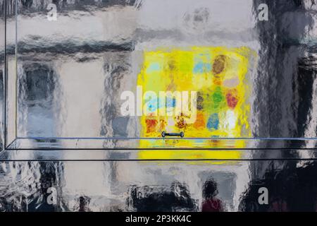 Colorato riflesso di un segno giallo sulla carrozzeria nera lucida di un camion alimentare a Bruxelles. Foto Stock