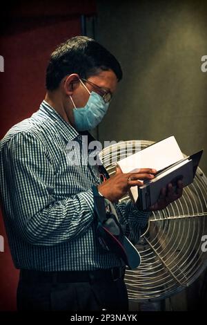 Kolkata, India - 12 febbraio 2023: Un ritratto di un uomo che ha letto un libro alla Fiera del Libro di Kolkata. Messa a fuoco selettiva. Foto Stock
