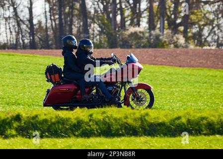 Uomo e donna non identificati con caschi in moto Foto Stock