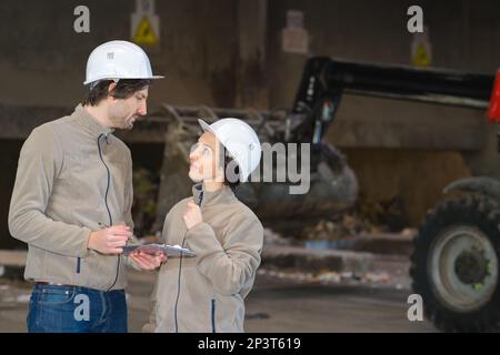 due lavoratori esperti che sovrintende all'interno di una fabbrica Foto Stock