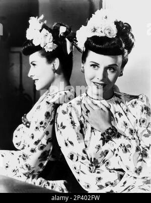 L'attrice americana PAULETTE GODDARD ( 1910 - 1990 ) - CINEMA - chignon - specchio - specchio - riflesso - fiori - fiori - rosa - rosa - anelli - anello - anelli - anelli - anelli - anelli - braccialetto - bracciale - bracciale - orecchini - orecchini - orecchino - bijoux - gioielleria - gioielli - profilo - Profilo - sorriso - sorriso - mani - mano - mani ---- Archivio GBB Foto Stock